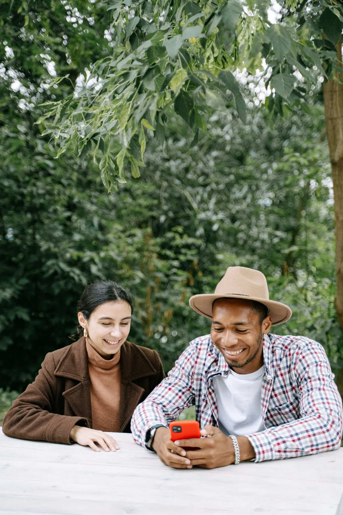 Due persone sorridenti usano l'app welfare Tundr sullo smartphone